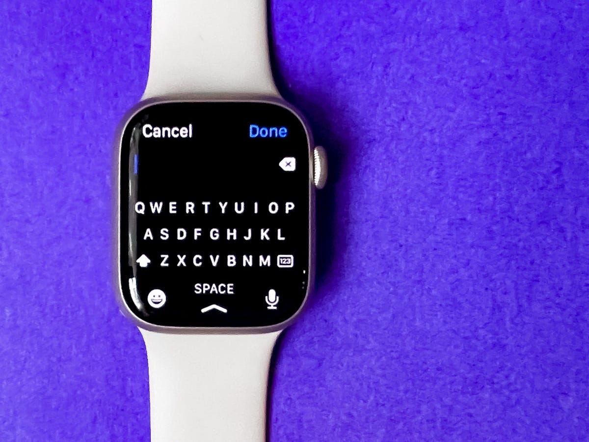 The Apple Watch Series 7 with the on-screen keyboard against a purple background